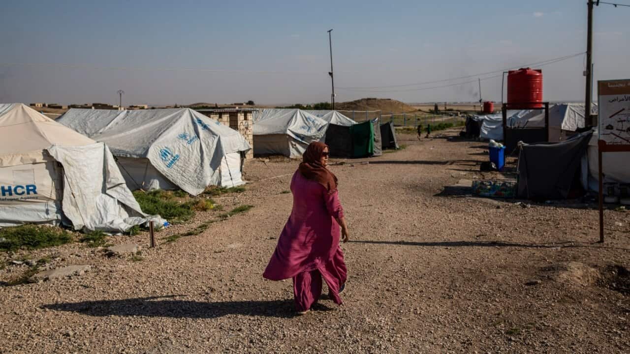 A woman walking alone in a refugee camp