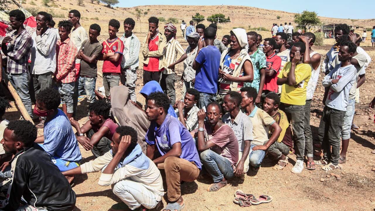 Ethiopian refugees queue for supplies after crossing the border into Sudan