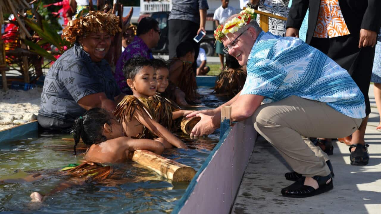 Children symbolically representing climate change greet Prime Minister Scott Morrison as he arrives for the Pacific Islands Forum