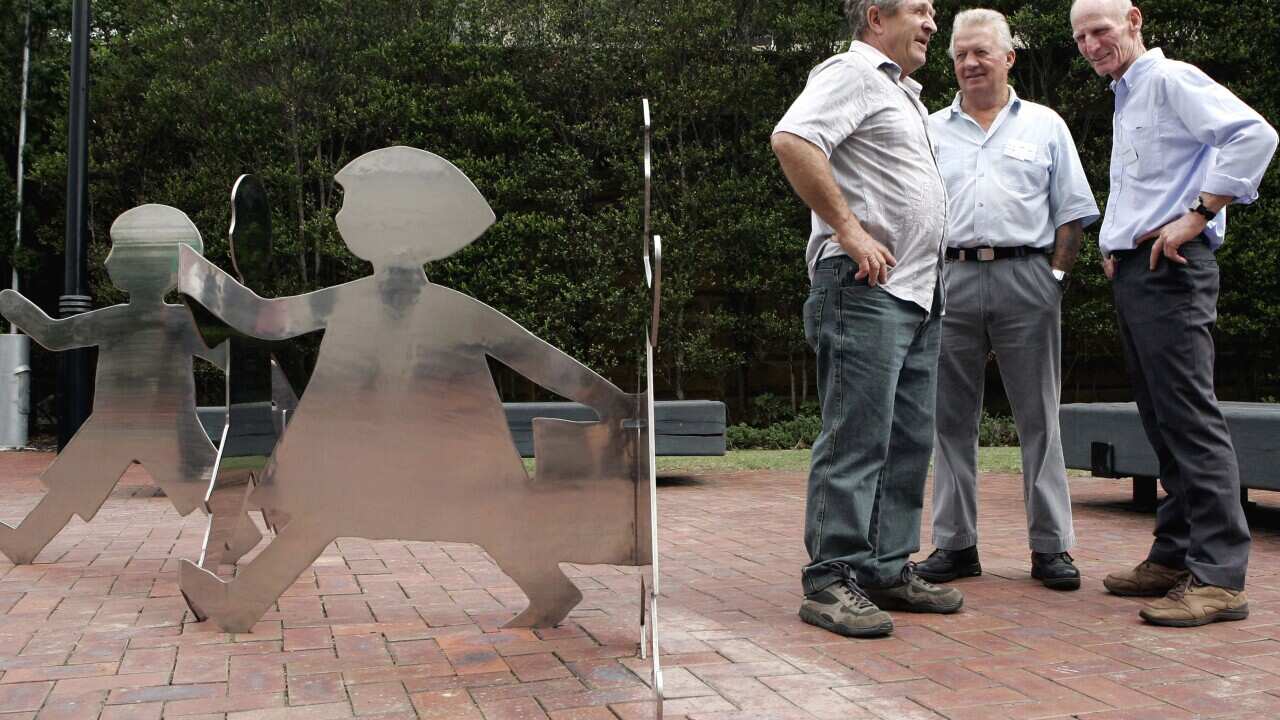 hild migrants from the UK, stand next to a new sculpture that represents the thousands of migrant children who came unaccompanied to Australia in the 70s.