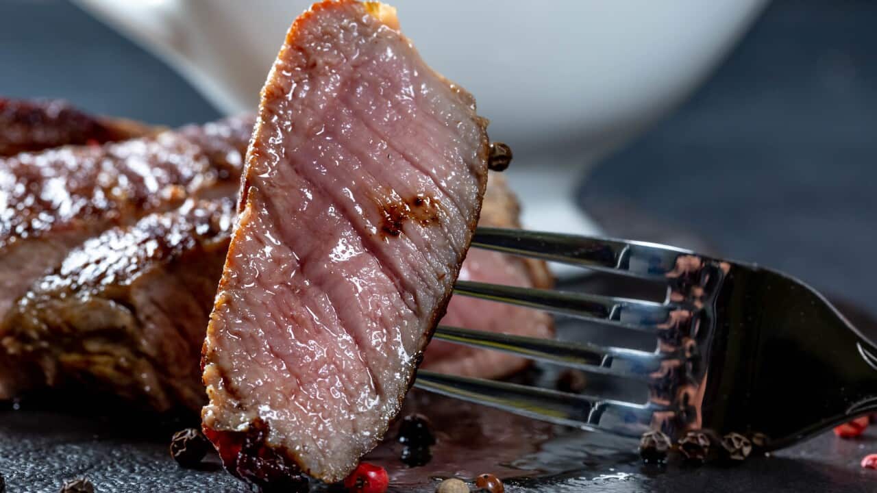 Close-up of a piece of juicy steak on a fork