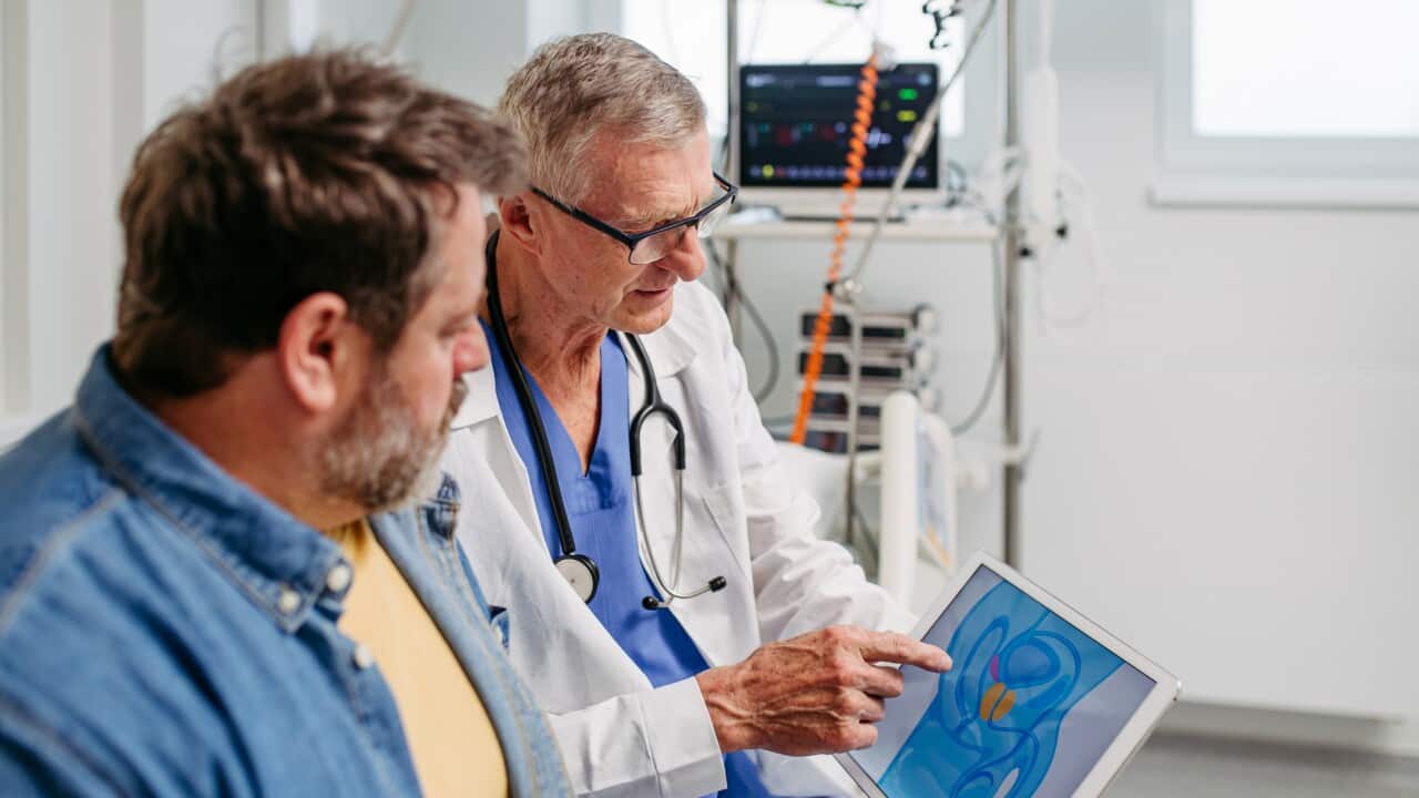 Doctor explaining prostate examination to male patient.