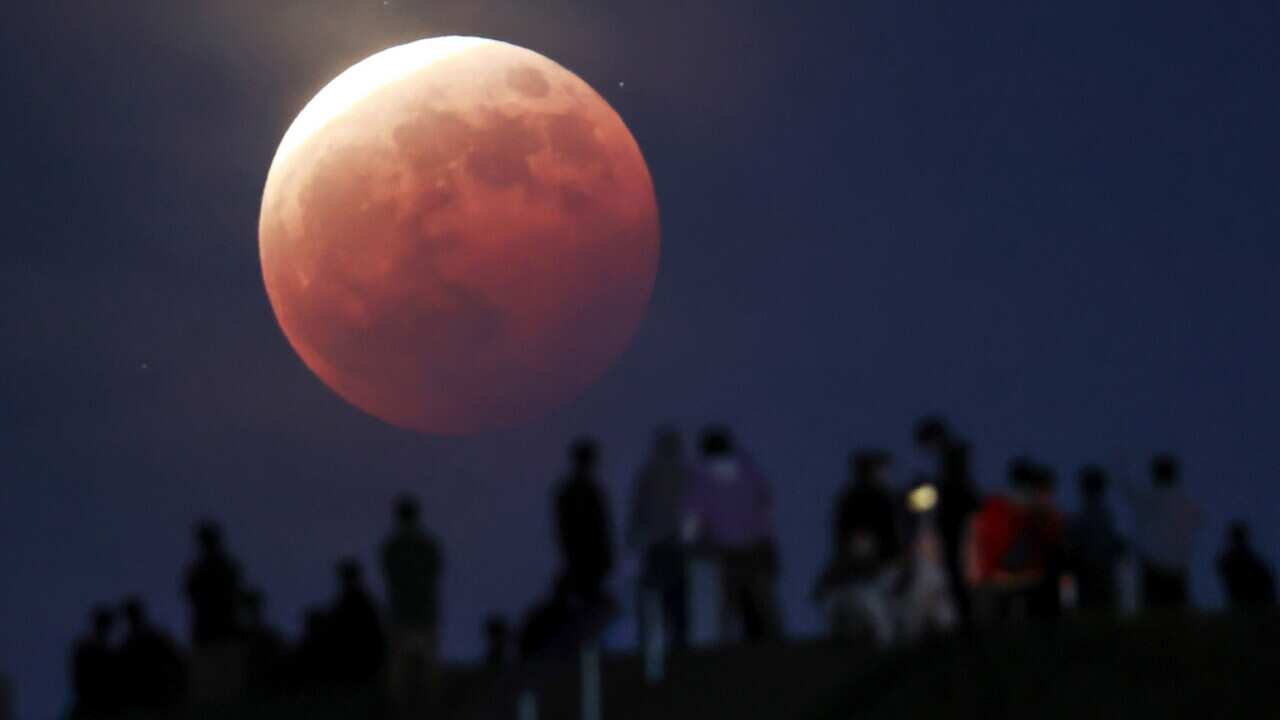 People watch the total eclipse of the moon at Moerenuma Park in Sapporo, northern Japan, 26 May 2021, as the super moon is passing through the shadow of the earth. EPA/JIJI JAPAN OUT EDITORIAL USE ONLY/ NO ARCHIVES