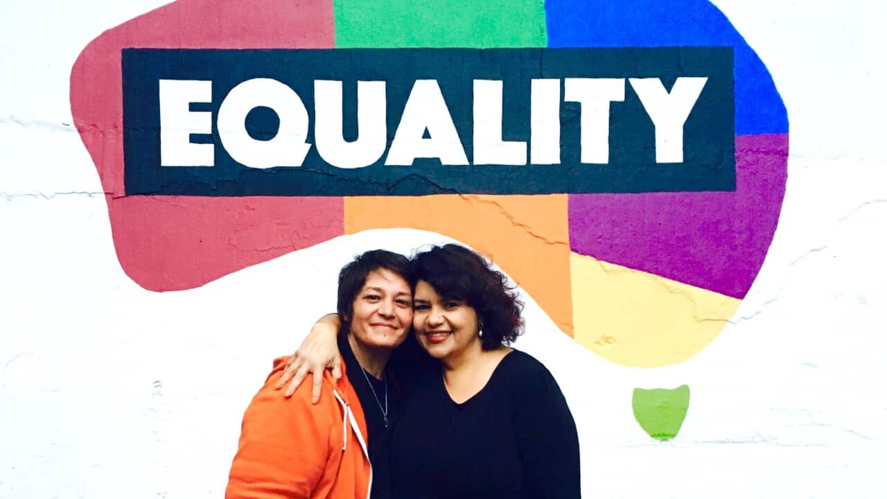 Kirste Parker and her partner De stand under the Equality mural