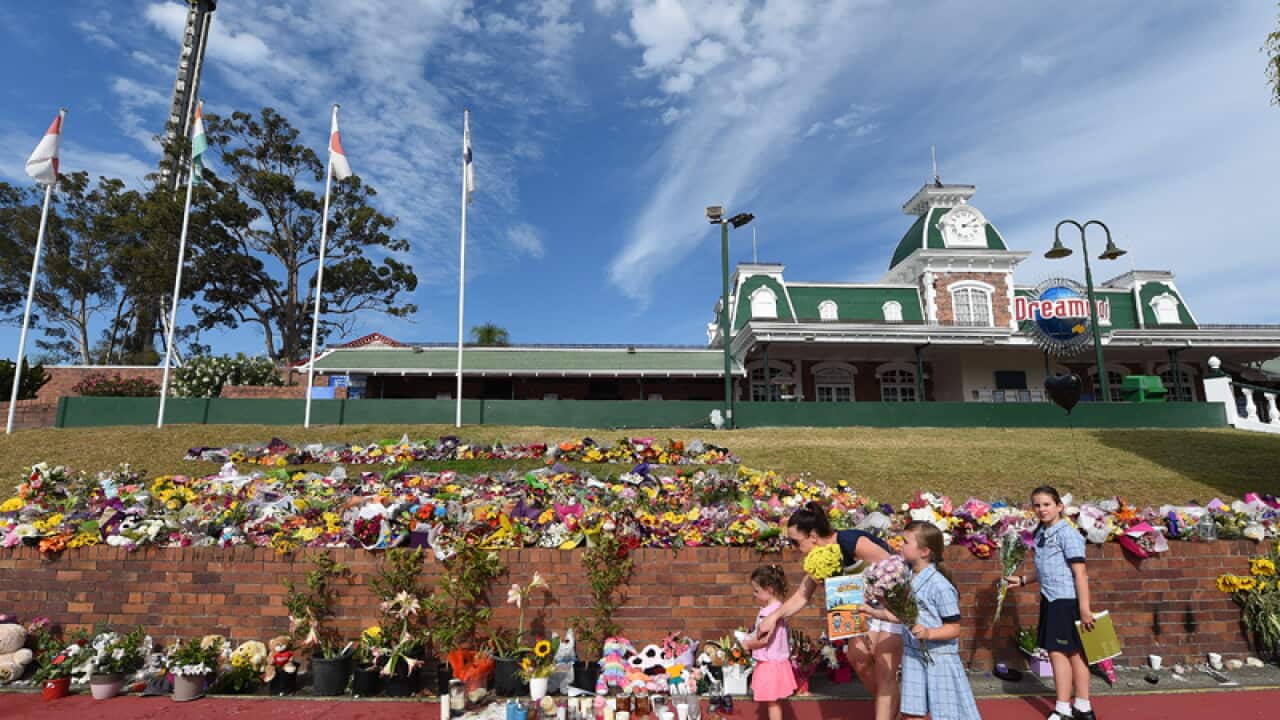 A family lays flowers outside the Dreamworld theme park
