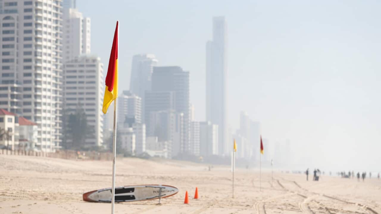 Smoke haze from local bushfires obscures the skyline on the beach at Surfers Paradise on the Gold Coast