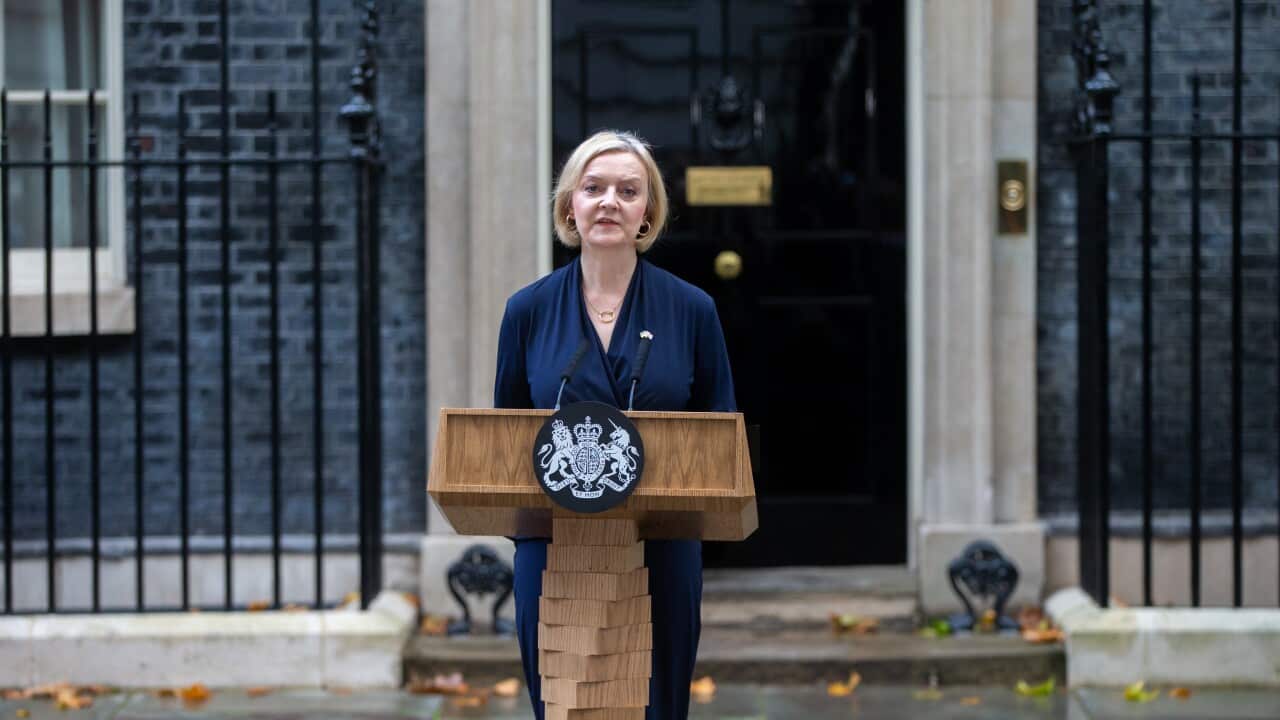 Liz Truss standing at a wooden lectern outside