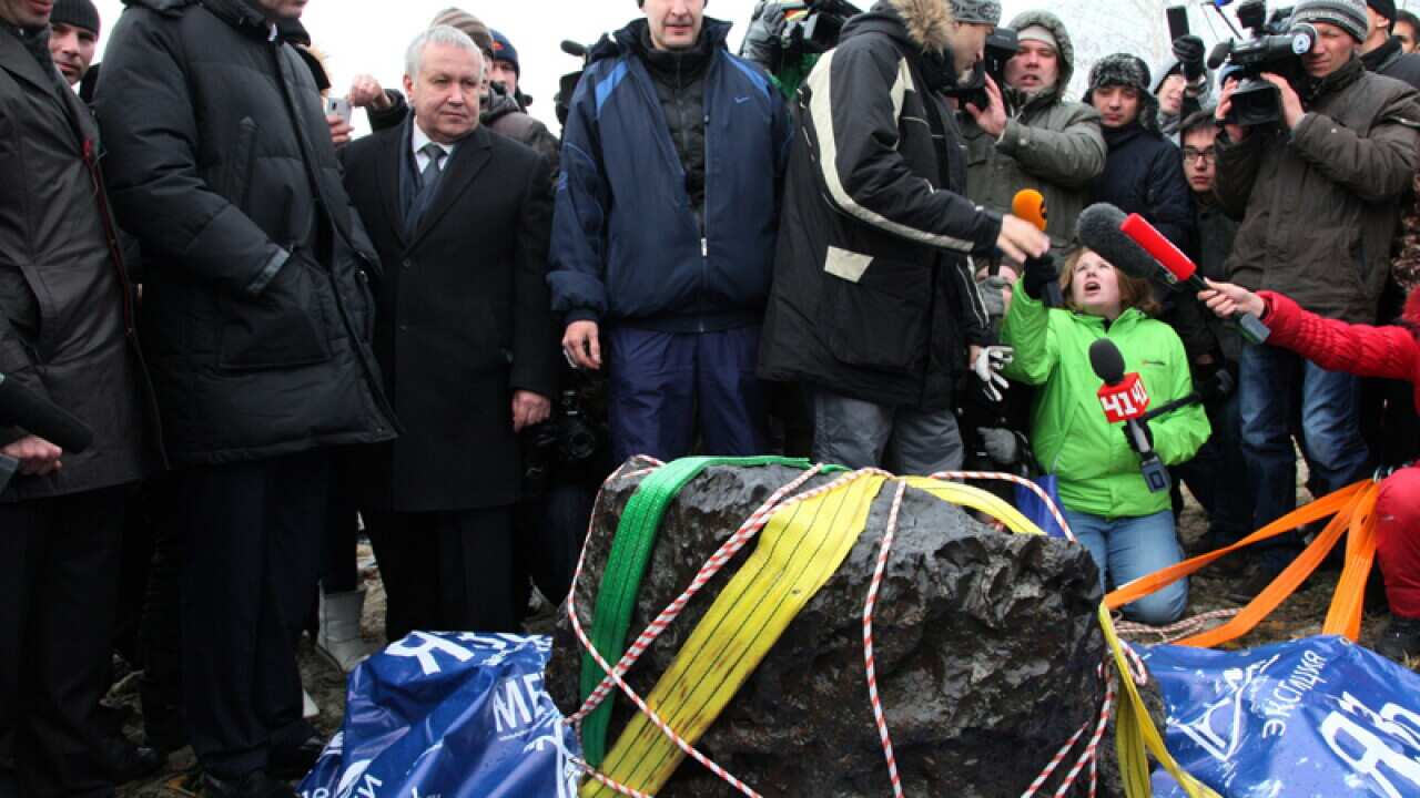 People look at what scientists believe is a chunk of a meteorite