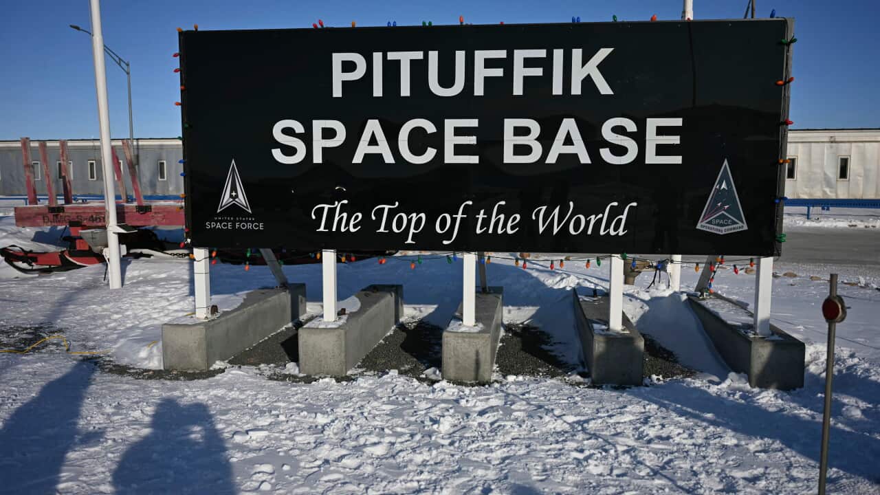 Sign reading “PITUFFIK SPACE BASE” and “The Top of the World” stands on a snow-covered site, with US Space Force logos and low buildings visible in the background.