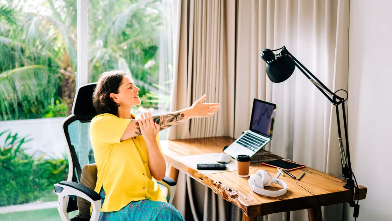 Woman stretching while working remotely at home office