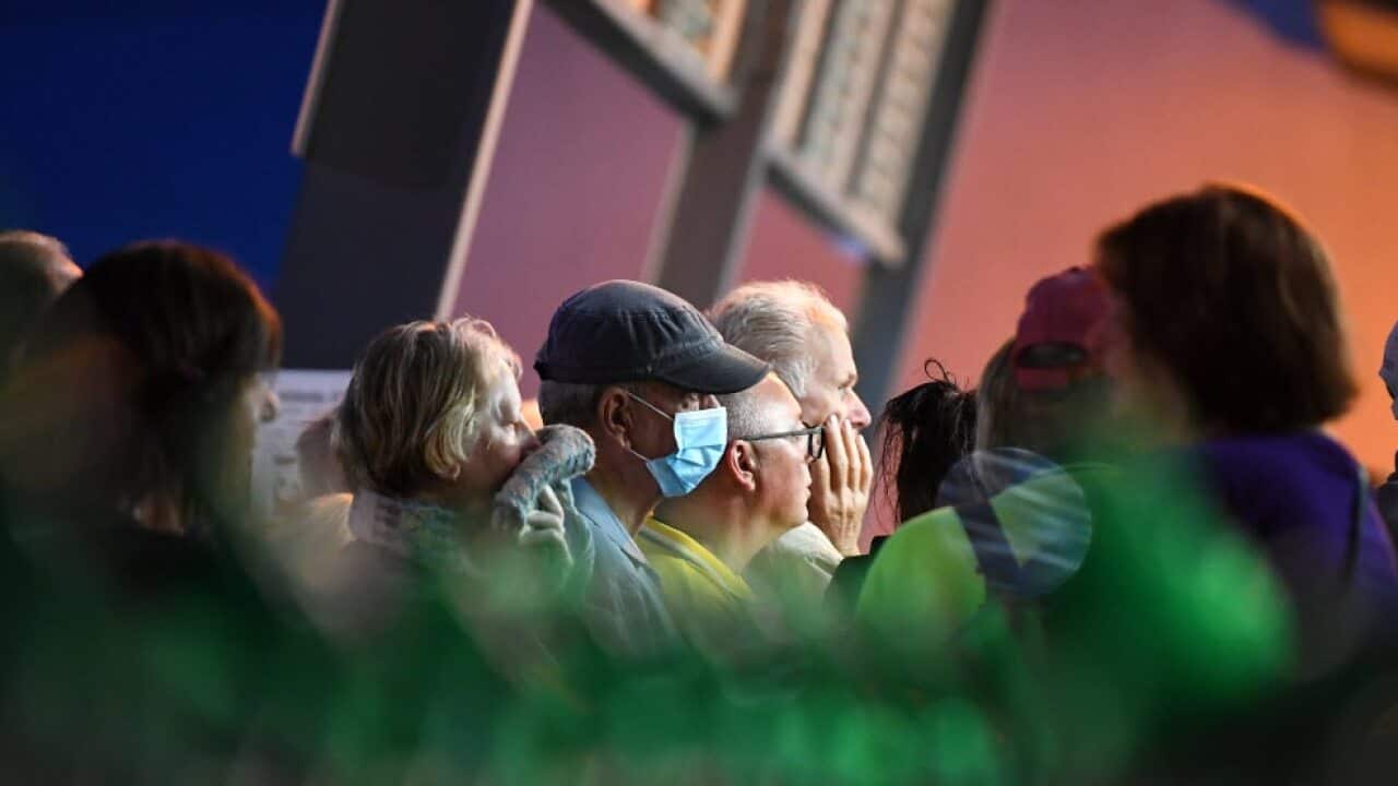 People are seen waiting in line outside a Woolworths supermarket in Coburg, Melbourne, 19 March, 2020.