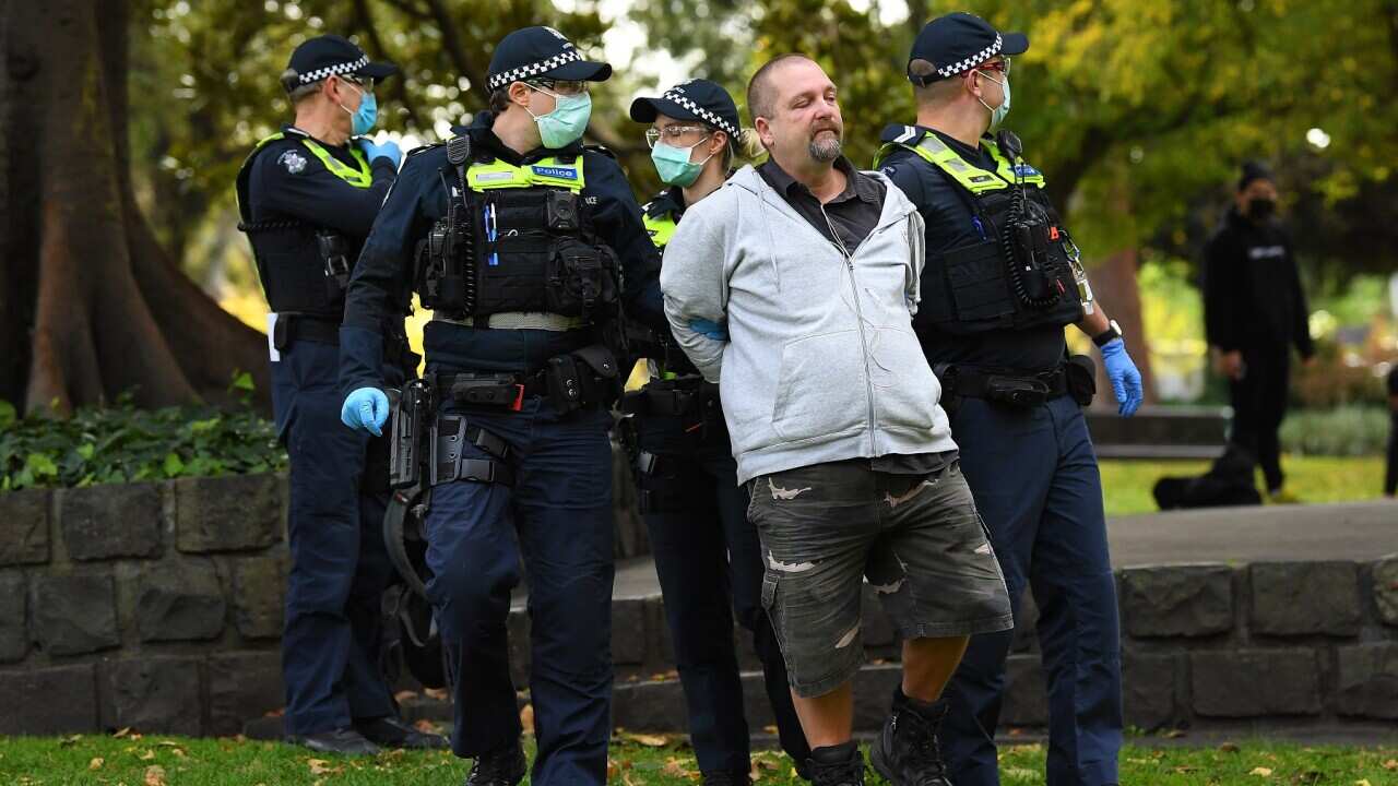 Police detain a protester at Flagstaff Gardens in Melbourne, Saturday, May 29, 2021.
