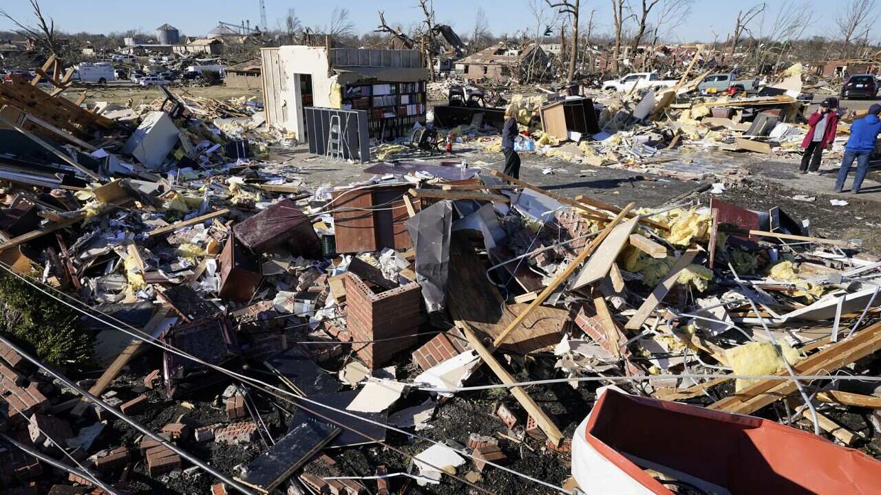 People retrieve items from a destroyed law office Sunday, Dec. 12, 2021, in Mayfield, Ky.