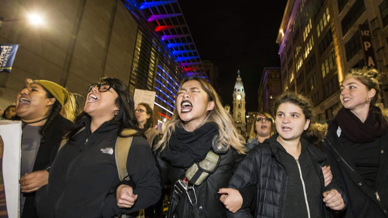 PRotesters unhappy with the presidential election march north on Broad St. arm-in-arm Thursday, Nov. 10, 2016, in Philadelphia. (Charles Fox/The Philadelphia Inquirer via AP)