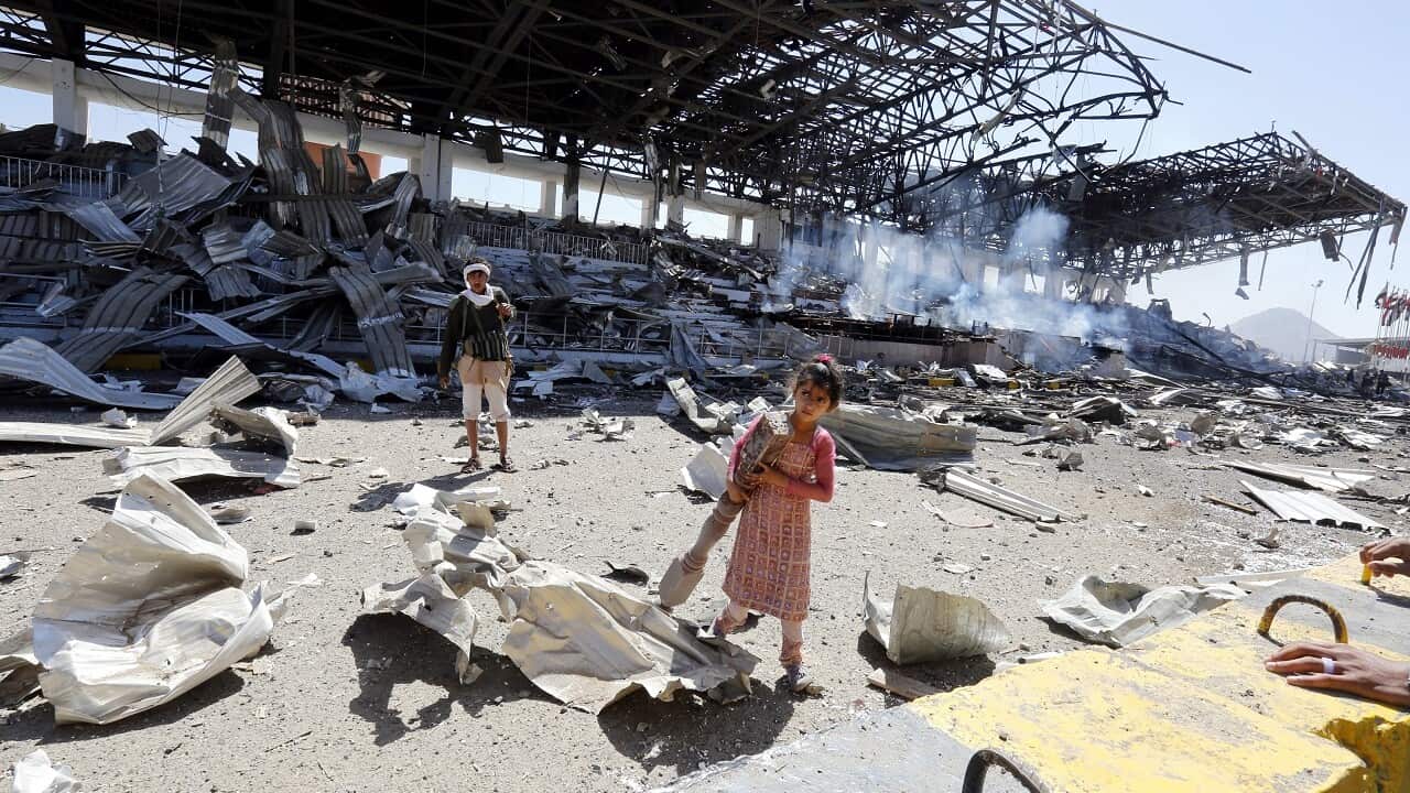 A Yemeni girl a Houthi militiaman at the site of an alleged Saudi-led airstrike, a day after Houthi rebels fired a ballistic missile at the Saudi capital.