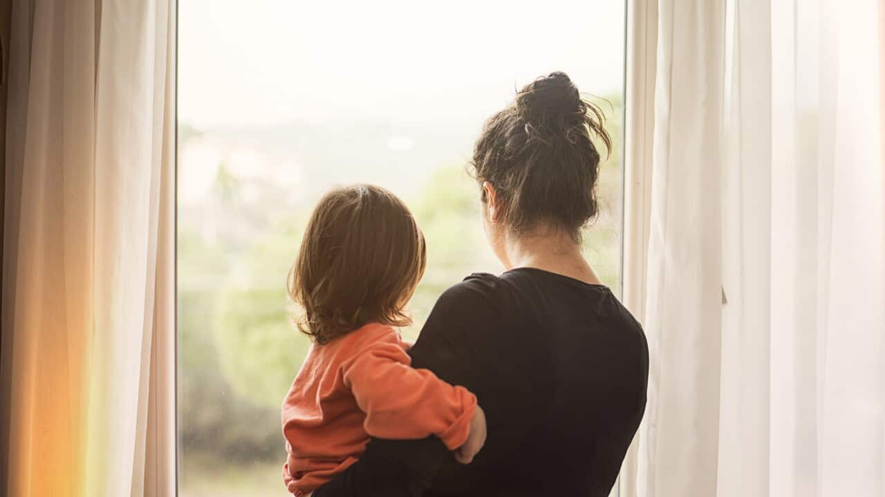 Mother and son looking out of window