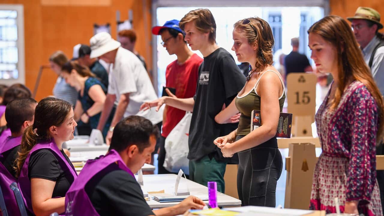 People sign in at a voting place.