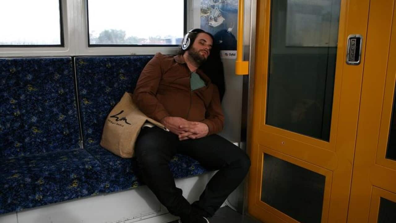 A man sleeps on a city train