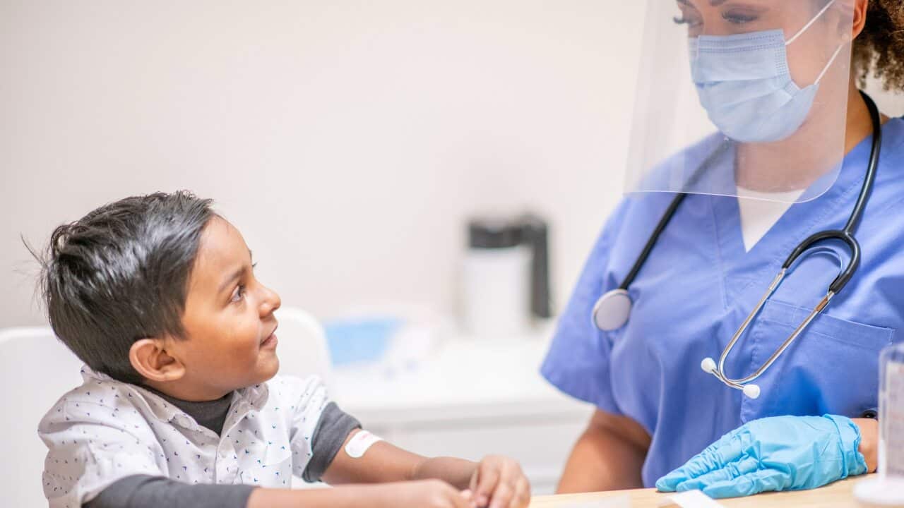 A child receiving a vaccine from a healthcare worker.