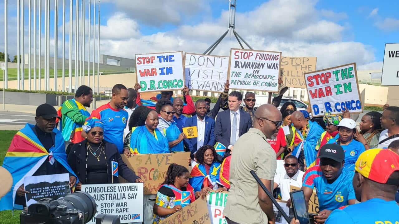 Mwenyekiti wa Jumuiya yawa Australia wenye asili ya DR Congo Bw Fidele Future (katikati) akiwa na mbunge mbele ya bunge la taifa mjini Canberra, Australia.jpg