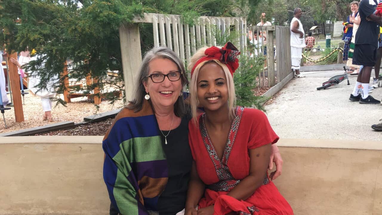 Rahel Davies and her mother sit on a bench
