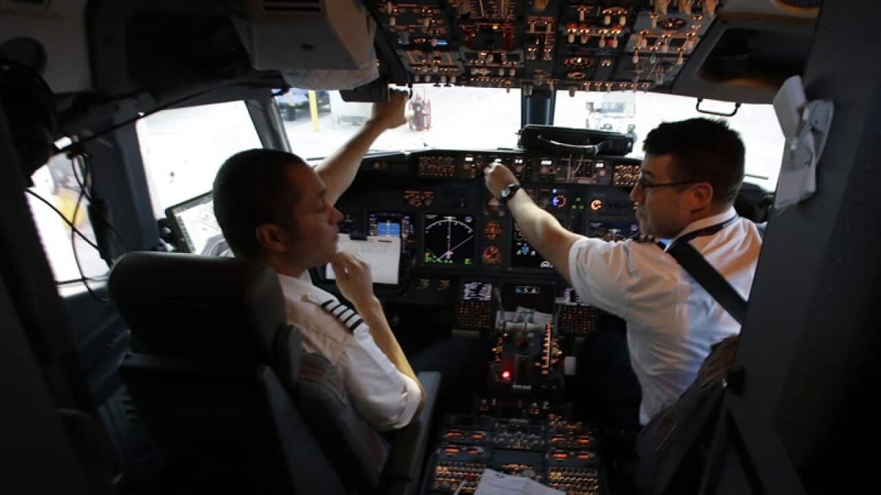 A Southwest Airlines pilot and co-pilot work in the cockpit