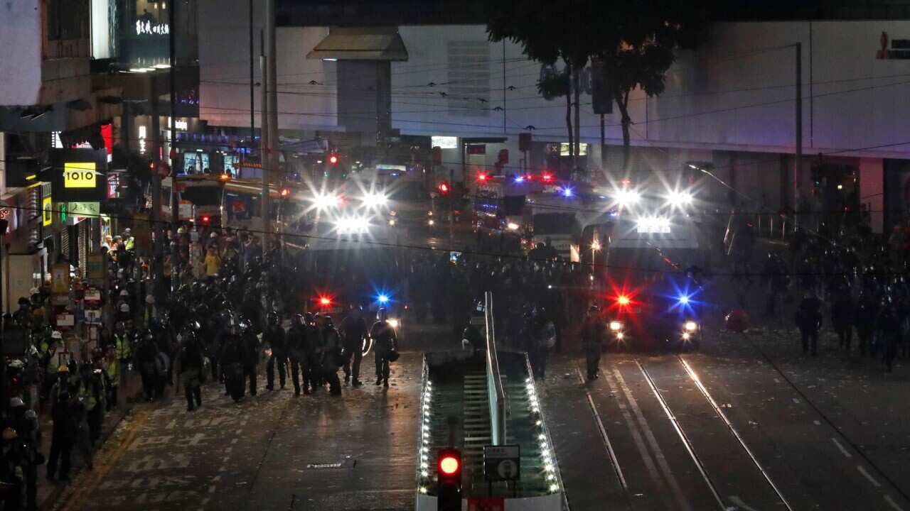 Riot policemen march on a street in Hong Kong.