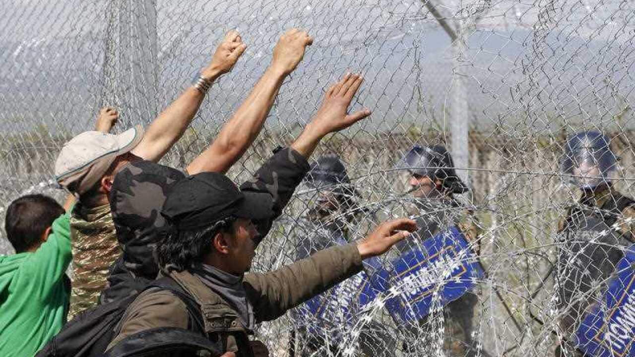 File image of a group of migrant men attempt to tear apart the fence during a protest at the northern Greek border point of Idomeni, Greece.