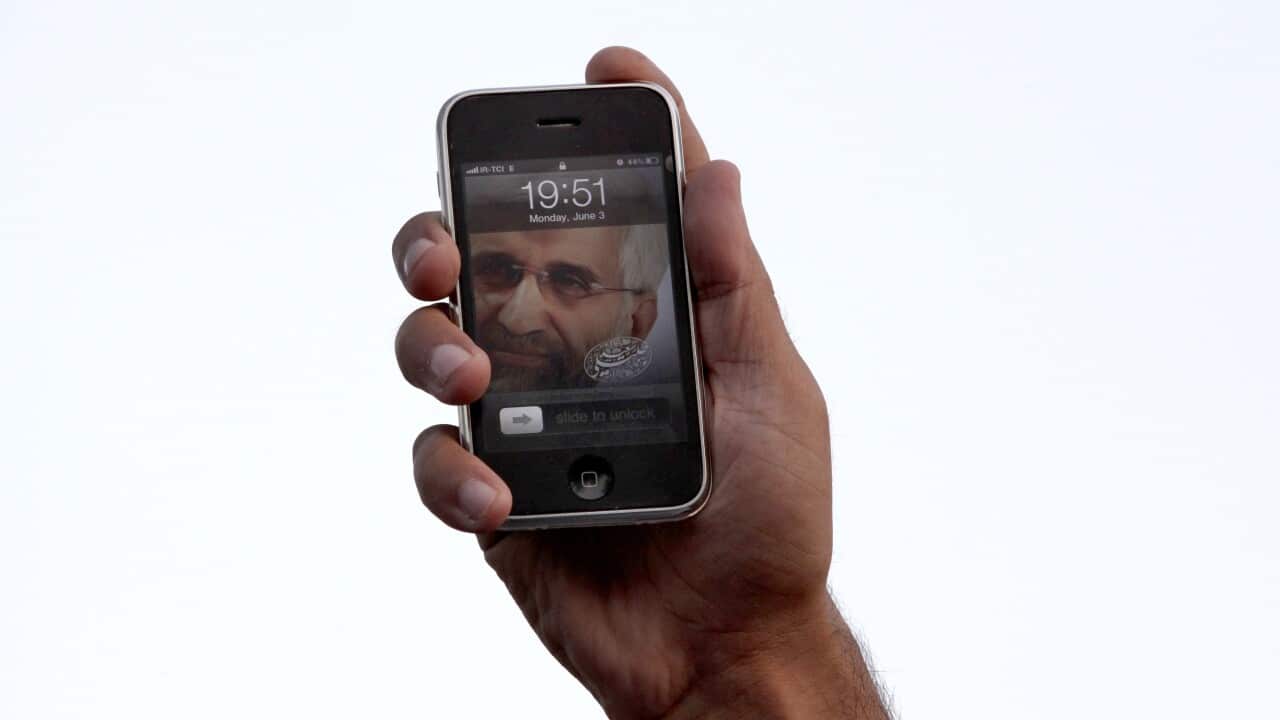 (File Image) A person holds up a smartphone in Tehran during Iran’s presidential election campaign in June 2013.