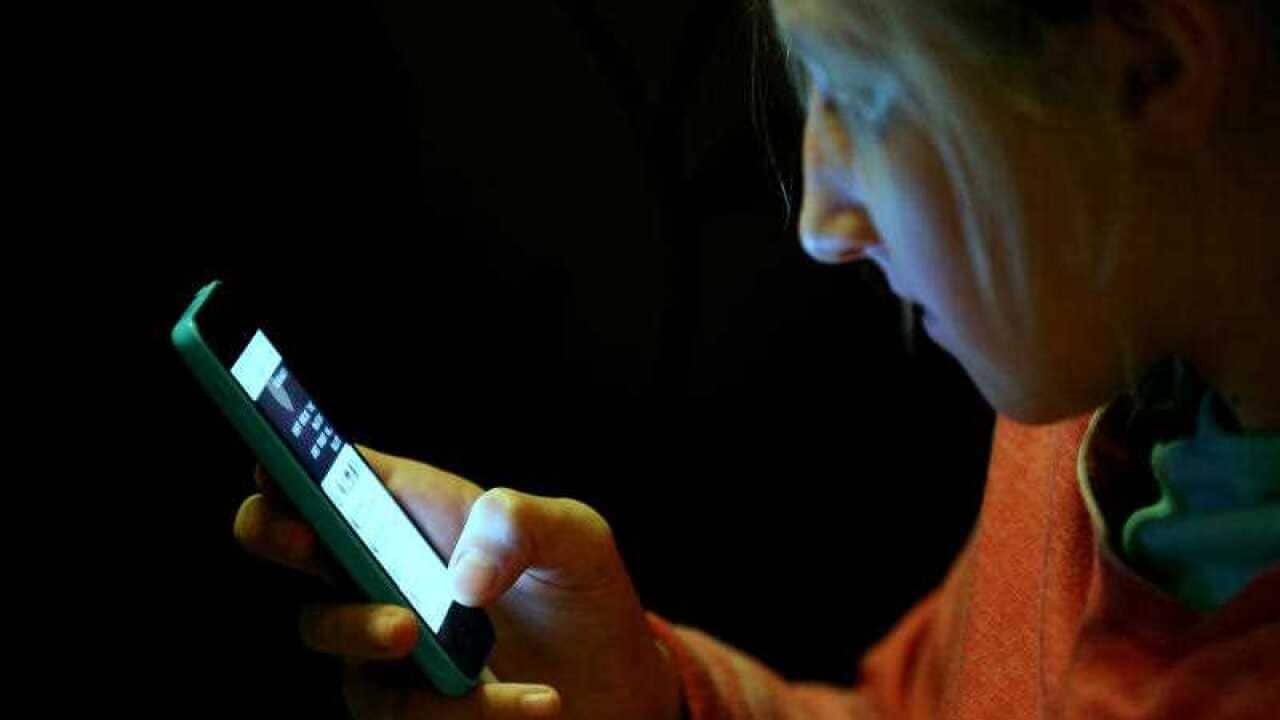teenage girl using an iphone mobile phone