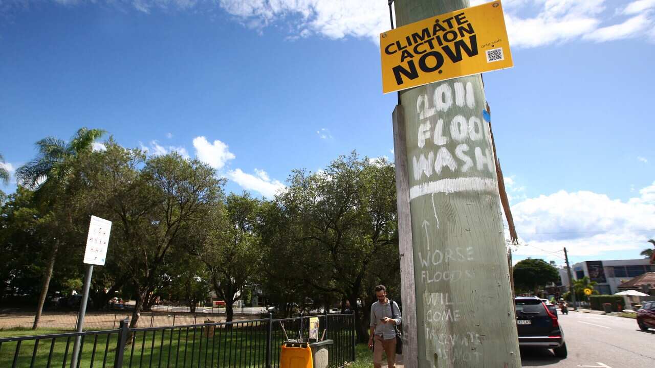 A climate change sign is seen in Milton, Brisbane, Monday, March 7, 2022. Queensland residents hit by floods in the southeast are facing months of recovery. (AAP Image/Jono Searle ) NO ARCHIVING