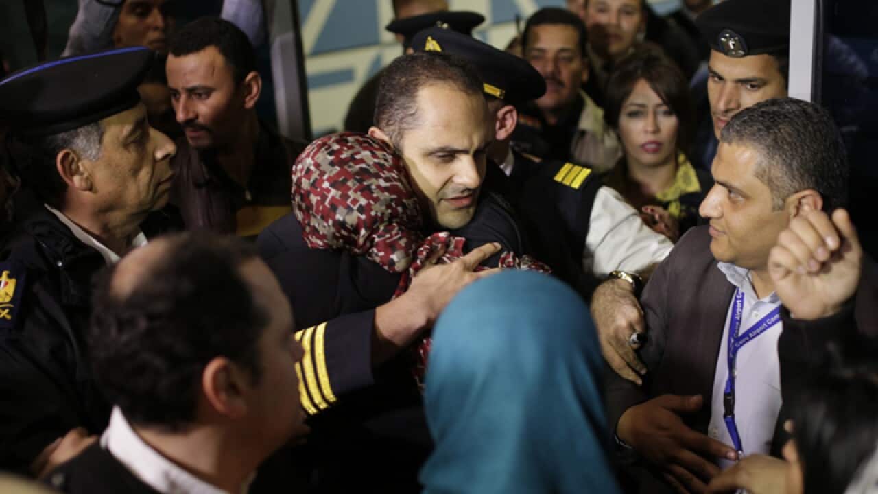 An EgyptAir crew member is hugged by relatives