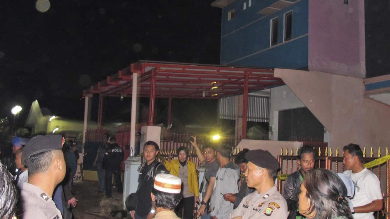 Officers stand guard around a house which was just raided by the police in Bekasi, West Java, Indonesia.