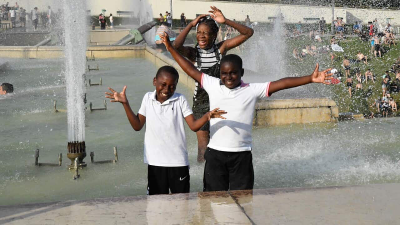 People cool off at the Trocadero Fountains in Paris, France