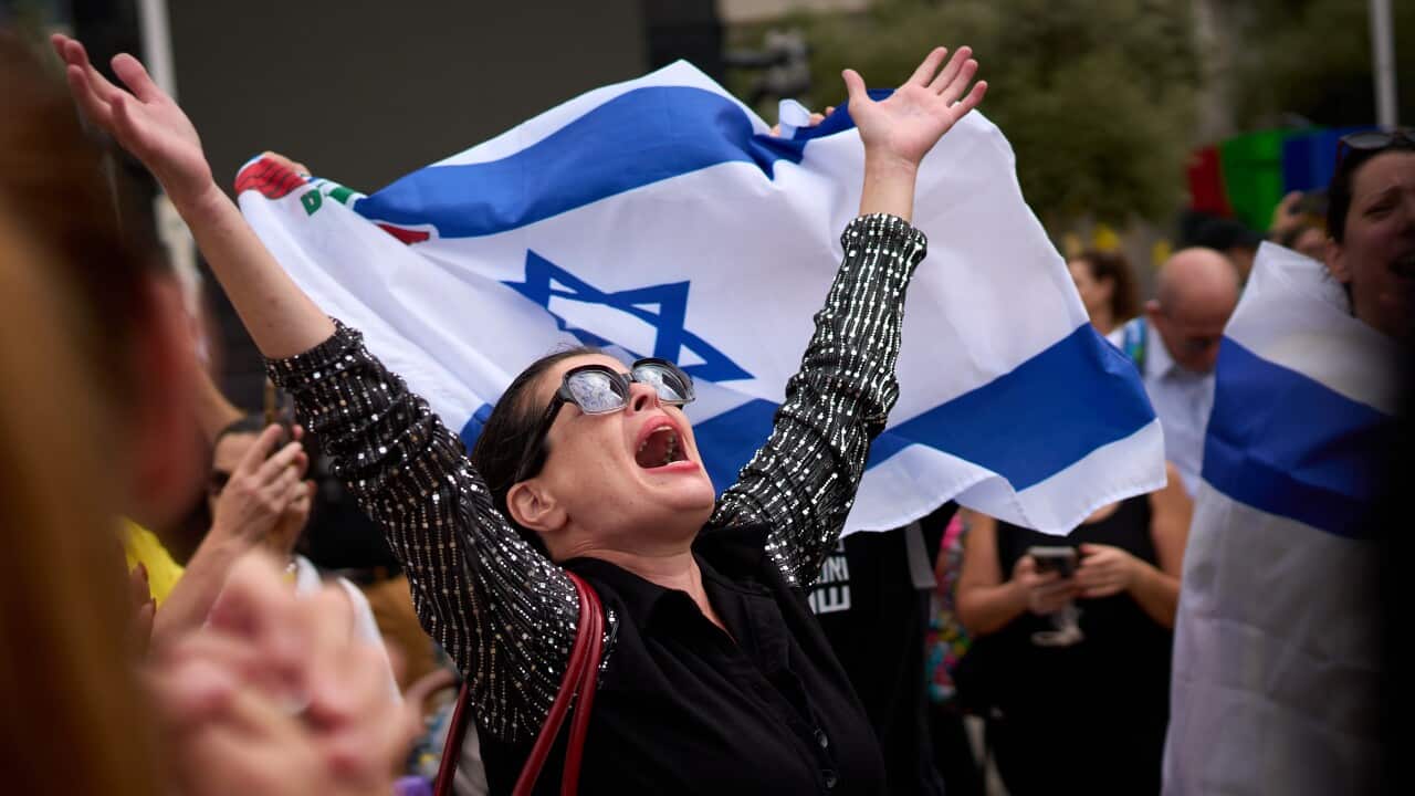 People react as they celebrate following the announcement that Israel and Hamas have agreed to the first phase of a peace plan to pause the fighting, at a plaza known as hostages square in Tel Aviv, Israel, Thursday, Oct. 9, 2025.