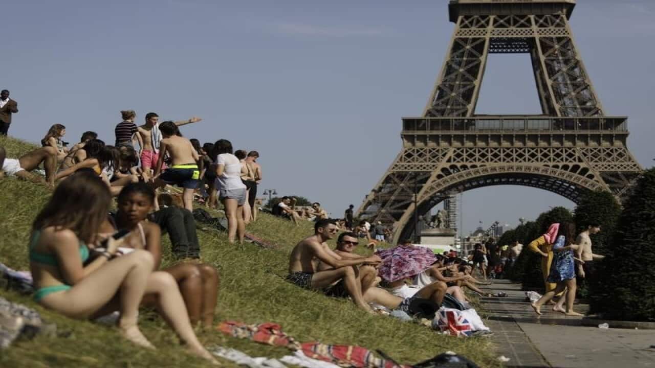 People enjoy the sun in the Trocadero Gardens in Paris