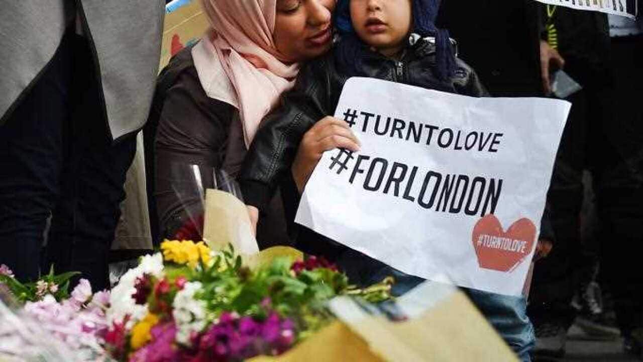 Members of London's Muslim community hold signs of condolence and support near the site of an attack at Borough Market in London, Britain, 04 June 2017.