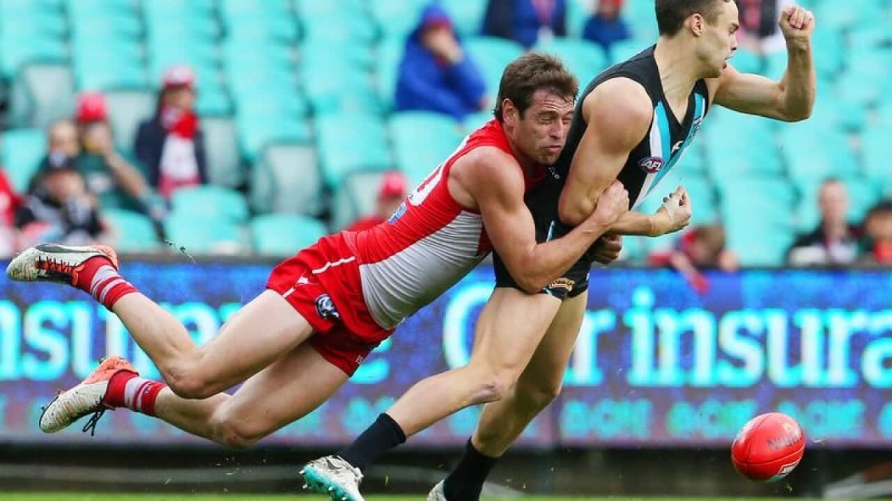 Nick Smith(left) of the Swans tackles Karl Amon of the Power
