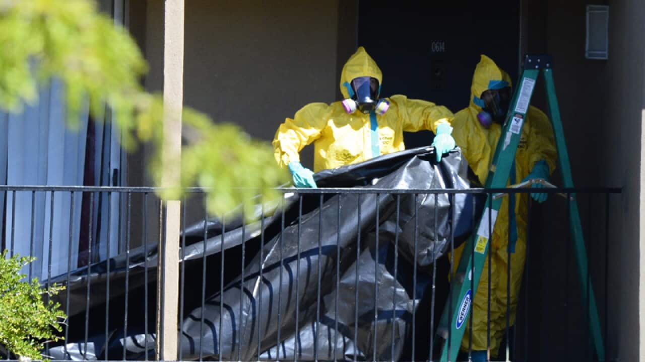 Hazmat members hang plastic at the apartment of Thomas Eric Duncan