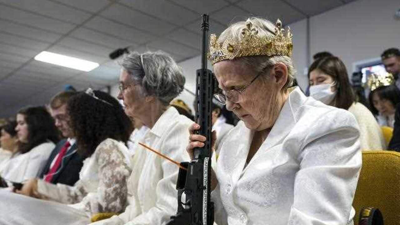 A parishioner with the Sanctuary Church holds onto her AR-15, which churchgoers were encouraged to bring to a blessing ceremony to rededicate their marriages