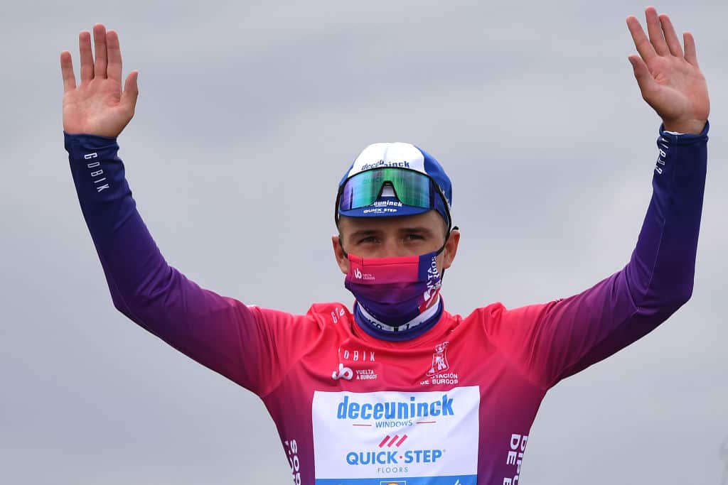 Remco Evenepoel sports the leader's jersey and matching mask at the Vuelta a Burgos 
