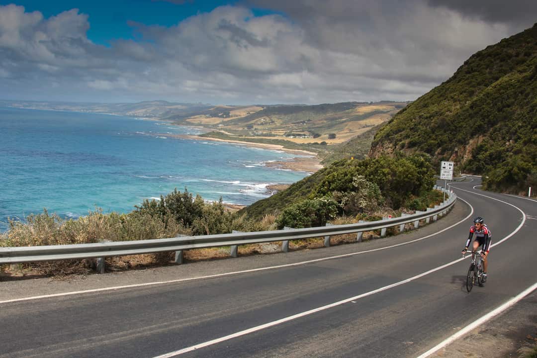 The Great Ocean Road, Victoria, Australia. Cyclist climbs to Cape Patton