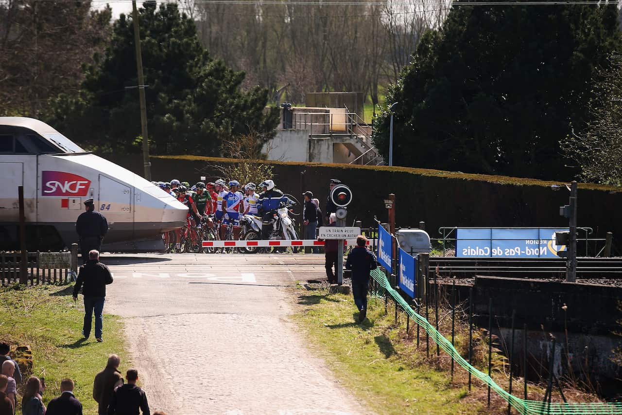 Riders contemplate the quickest route to Paris as a train interupts the race