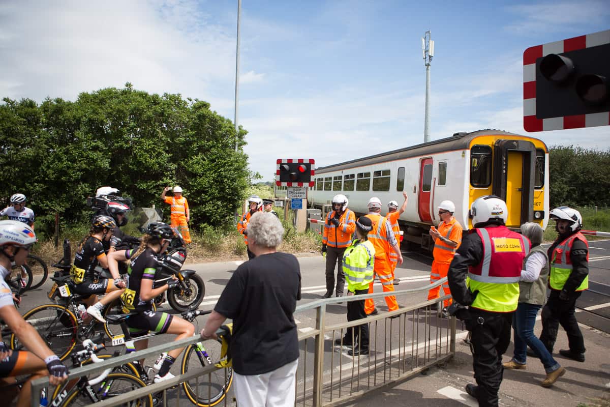 Riders wait at a train crossing in the Aviva Women's Tour