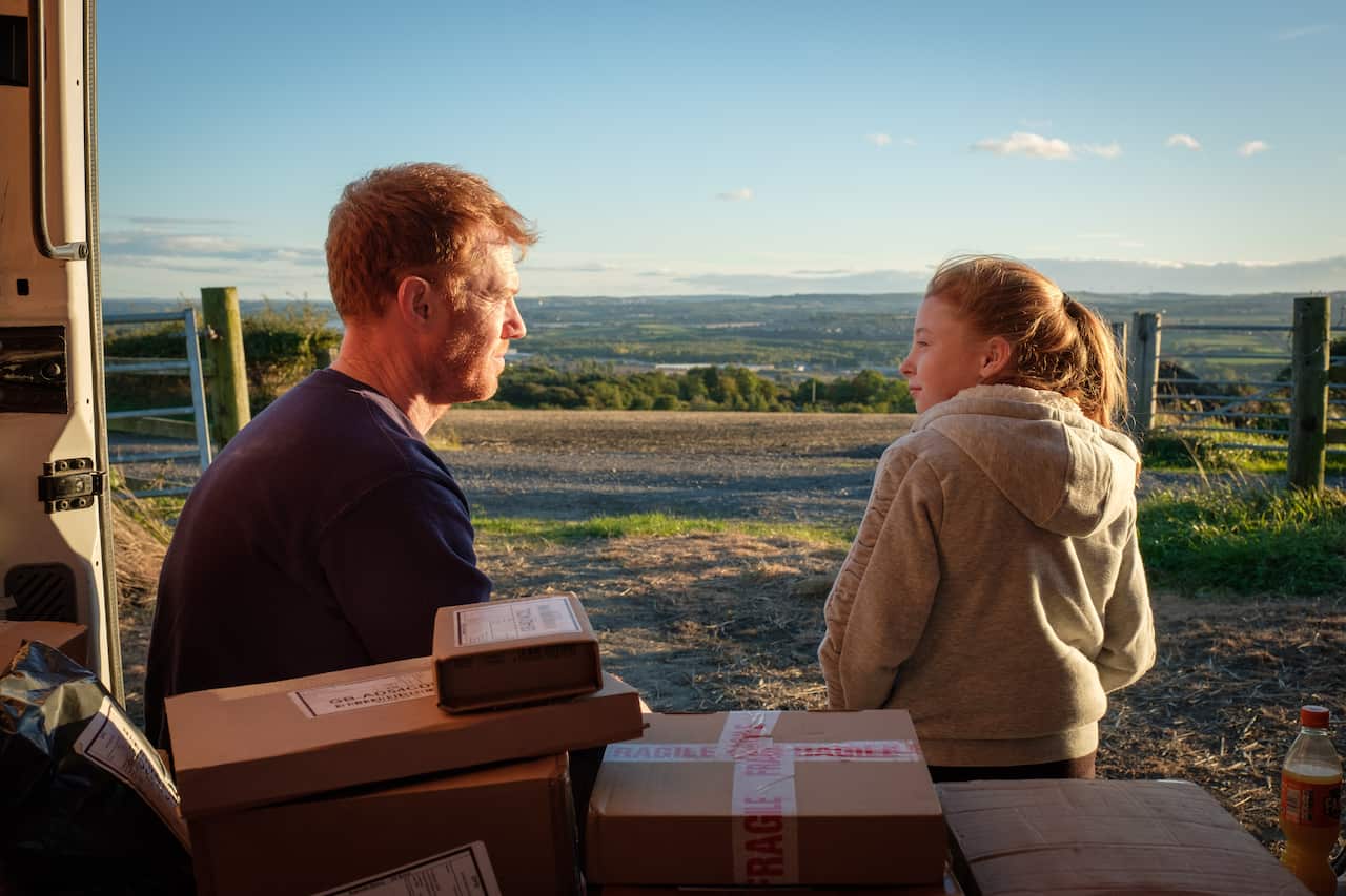 Father and daughter sitting in van with packages, press image for Sorry We Missed You film
