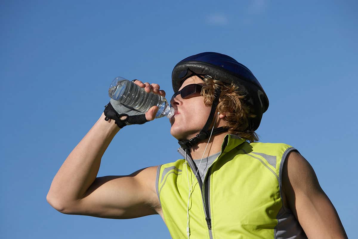  Male cyclist drinking from water bottle outdoors
