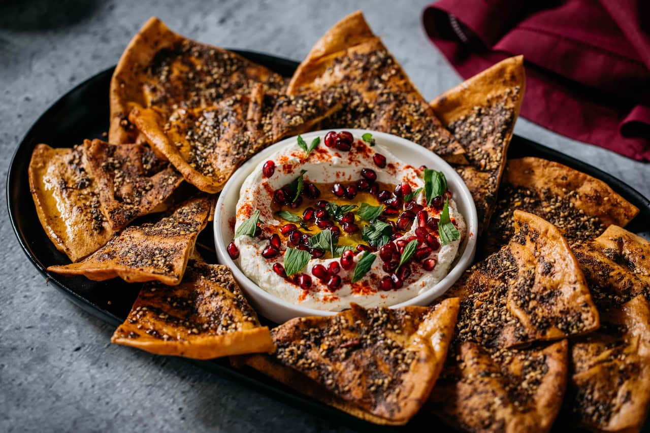 Labneh with pomegranate, baked za’atar pita