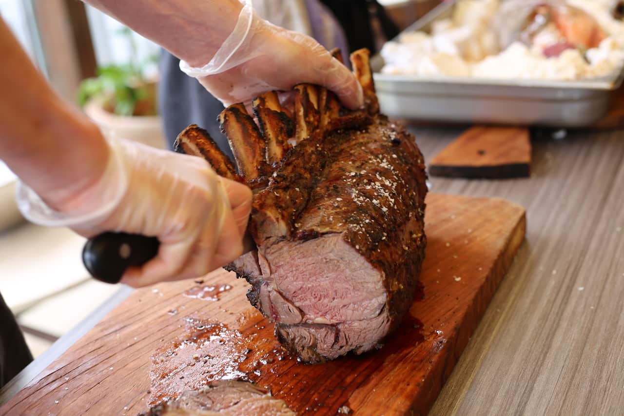 Osborn House’s executive chef, Segundo Farrell, cuts through a Wagyu tomahawk rib eye, slow-roasted over fire. 