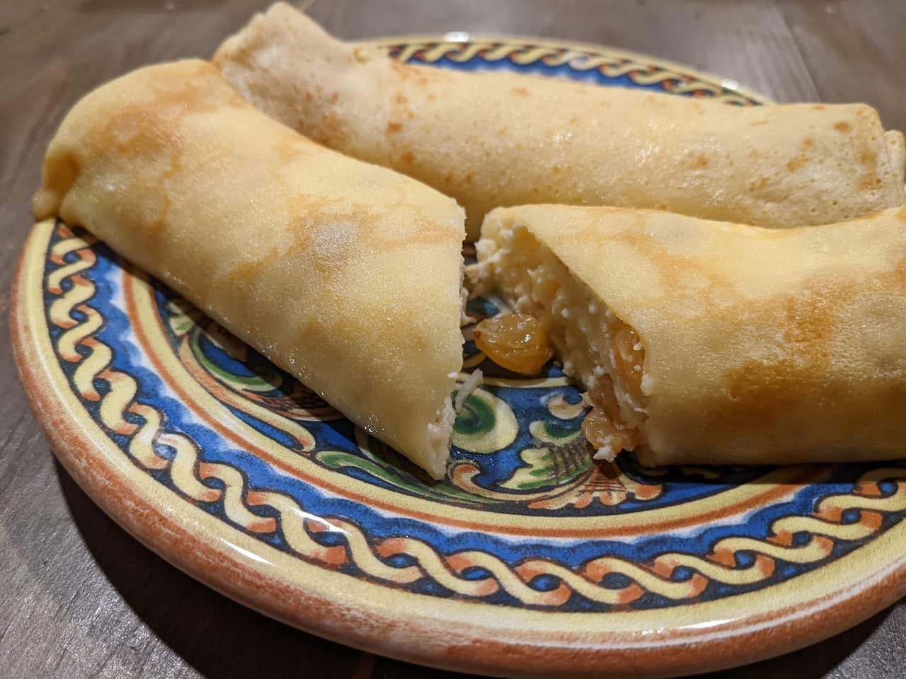 Nalysnyky (pancakes) stuffed with homemade cheese and raisins.