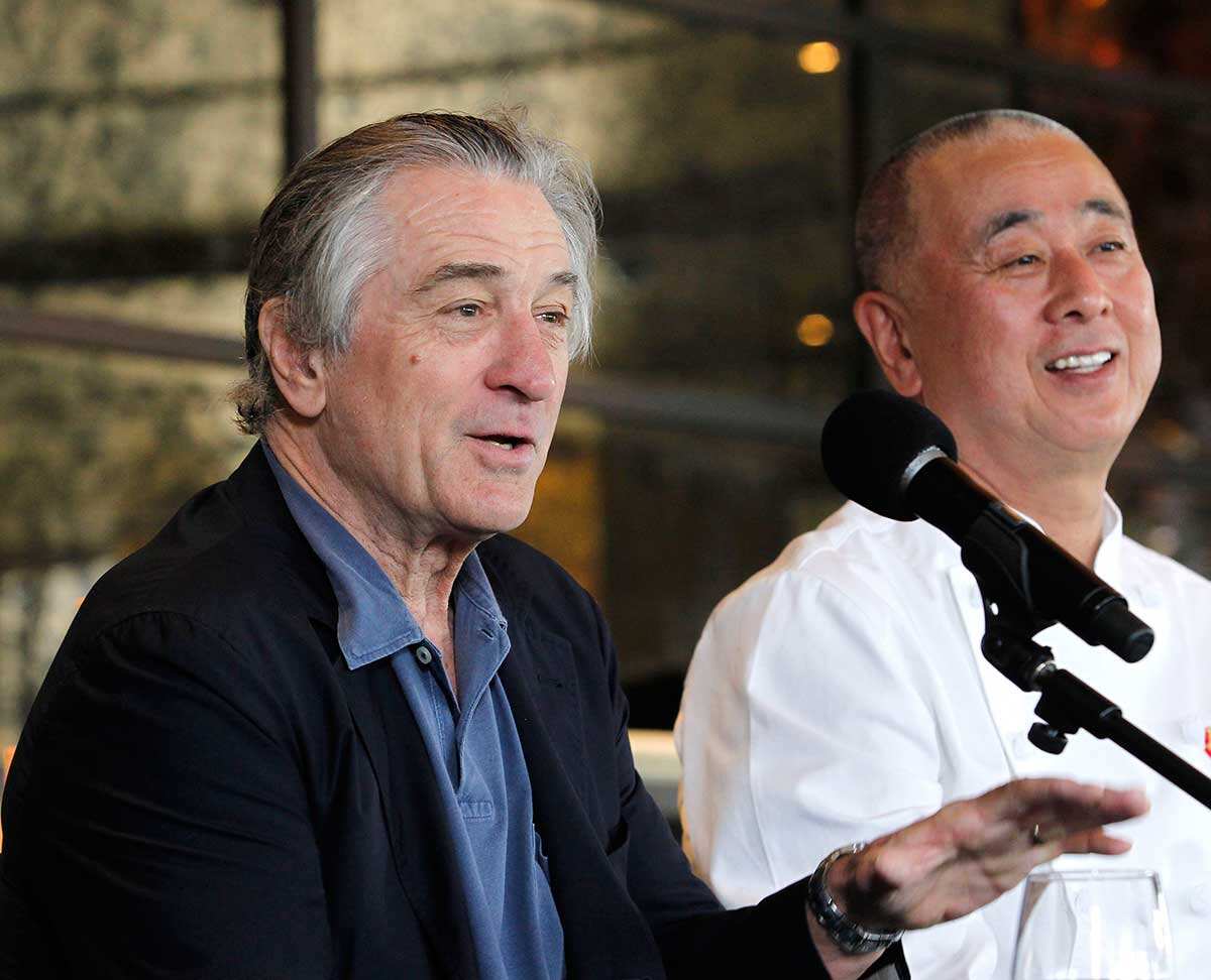 Actor Robert De Niro, left, speaks as chef Nobu Matsuhisa listens 